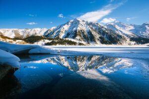 Big Almaty lake on december. Water, ice, mountains and snow.