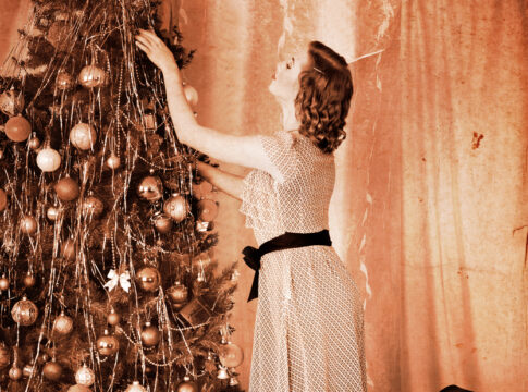 Woman dressing Christmas tree.
