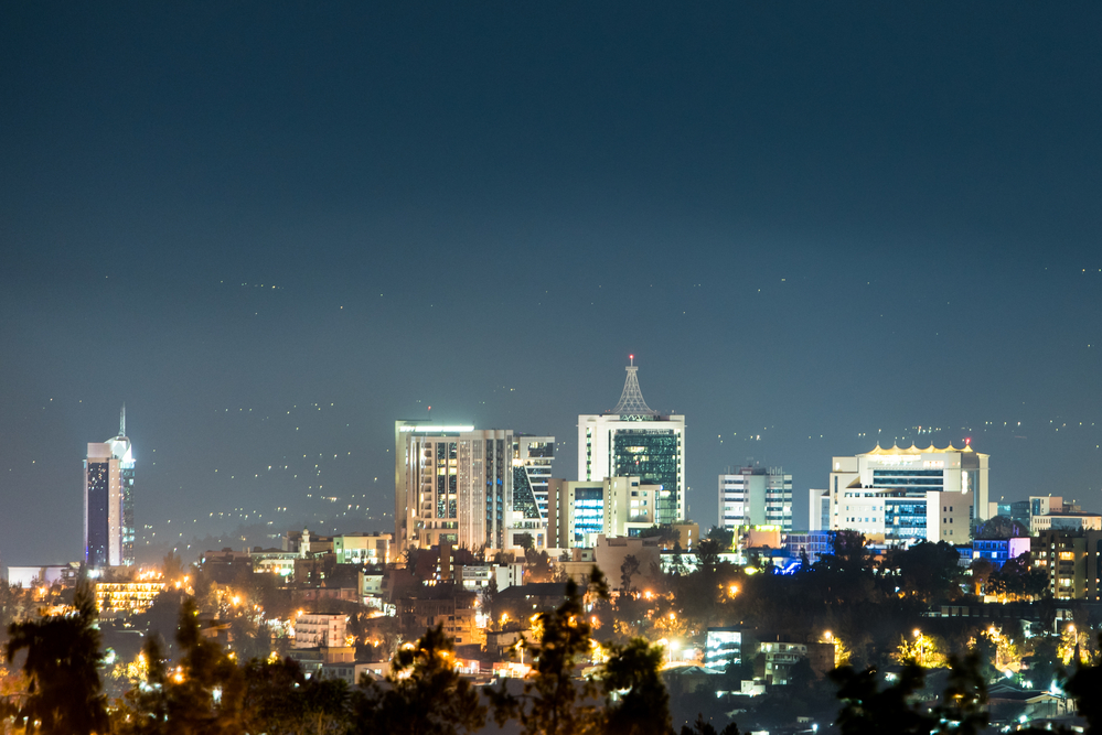 A closeup view of Kigali city skyline lit up at night, under a d