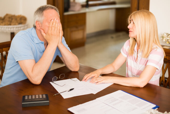 Worried couple calculating their expenses