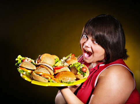 Woman holding hamburger.