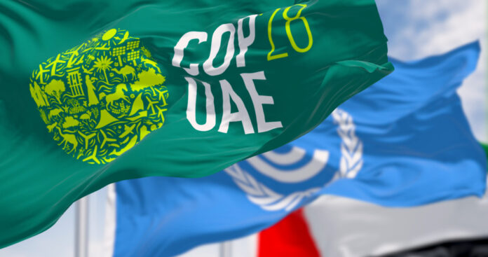 copout28 Flags of COP28, UNFCCC and UAE waving on a clear day.